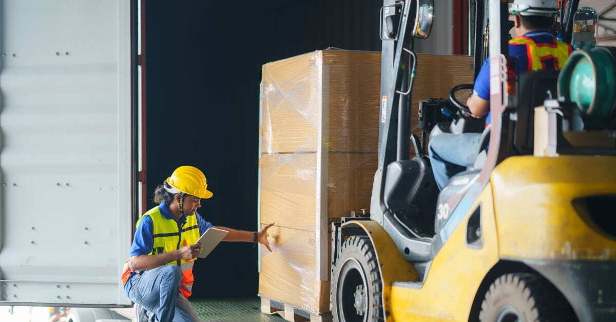 warehouse employees loading shipment into freight container
